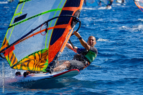 CLOSE UP: Action shot of male windsurfer riding waves on a sunny day in Dalmatia photo