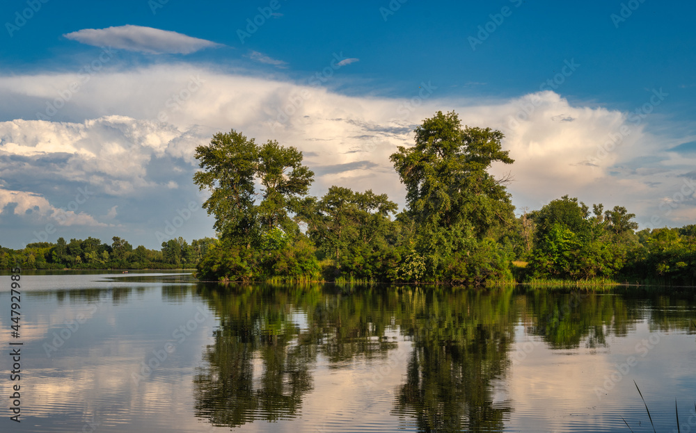 The river with the banks overgrown with forest. Hiking and water tourism. Beautiful nature.