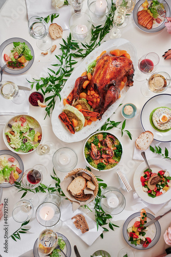 Beautiful festive table with variety of food and baked duck. Thanksgiving Day. Christmas. Top view. High quality photo