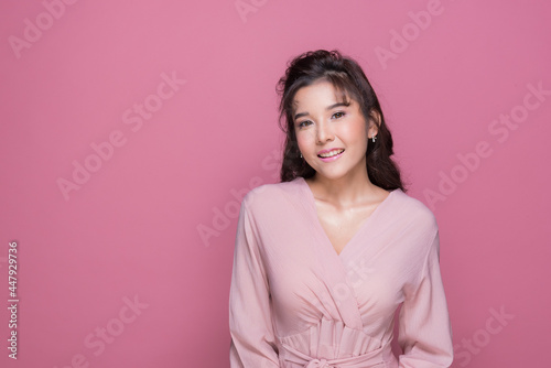 Portrait beautiful young woman in the studio on pink background 