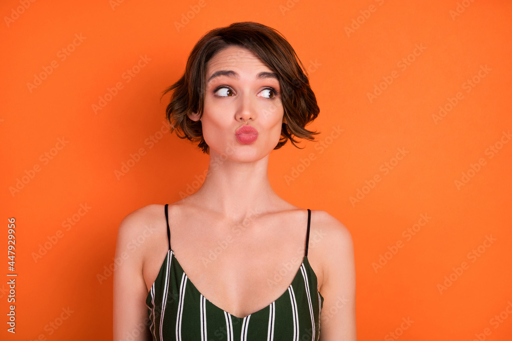 Photo of young girl pouted lips send air kiss flirty look empty space isolated over orange color background Photo of young girl pouted lips send air kiss flirty look empty space isolated over orange color background