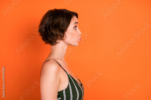 Profile side photo of young girl pouted lips feelings romantic look empty space isolated over orange color background