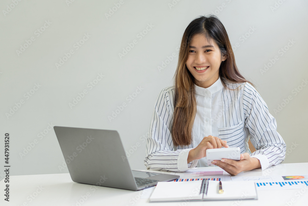 Young Asian businesswoman working on laptop and analyzing financial accounting graphs in home office Young Asian businesswoman working on laptop and analyzing financial accounting graphs in home office
