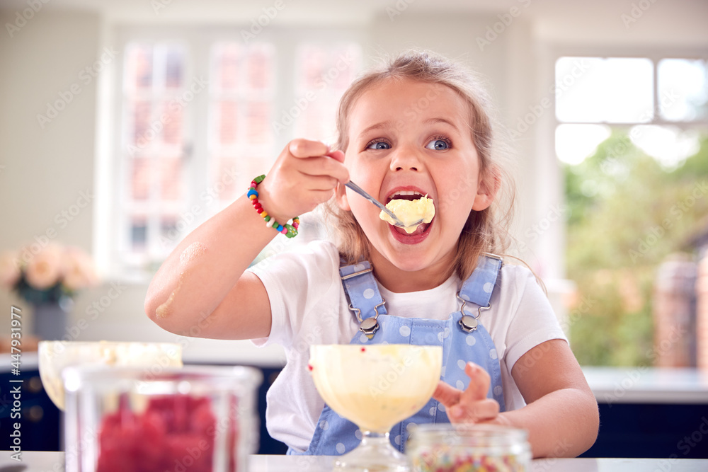 Young Girl In Kitchen Eating Ice Cream Dessert With Spoon Young Girl In Kitchen Eating Ice Cream Dessert With Spoon