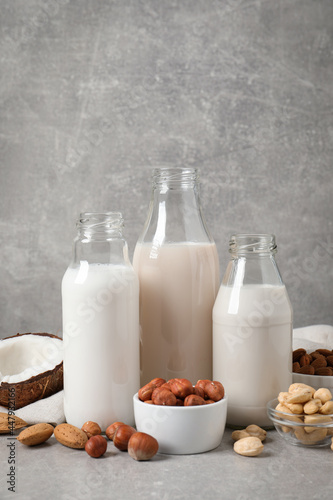 Different nut milks on light grey table