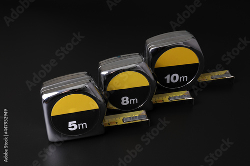 Flexometers or measuring tapes on black background photo