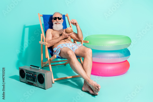 Εκτύπωση καμβά Photo of cute retired man naked torso lying beach chair drinking cocktail listen