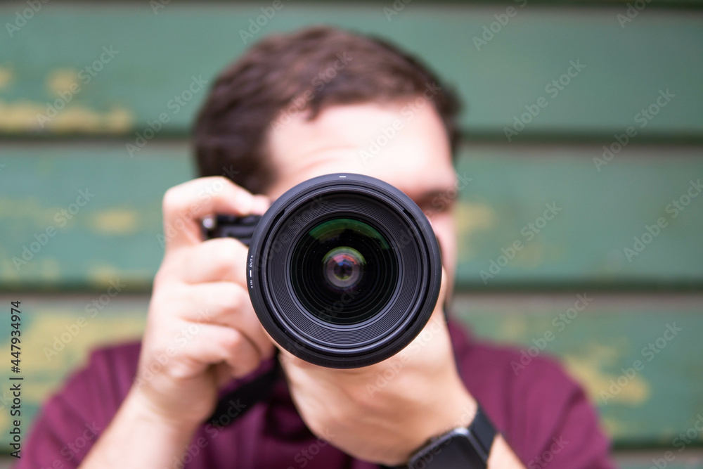 Half length of young beautiful man outdoor in the city holding digital camera, shooting - photography, creative, artist concept