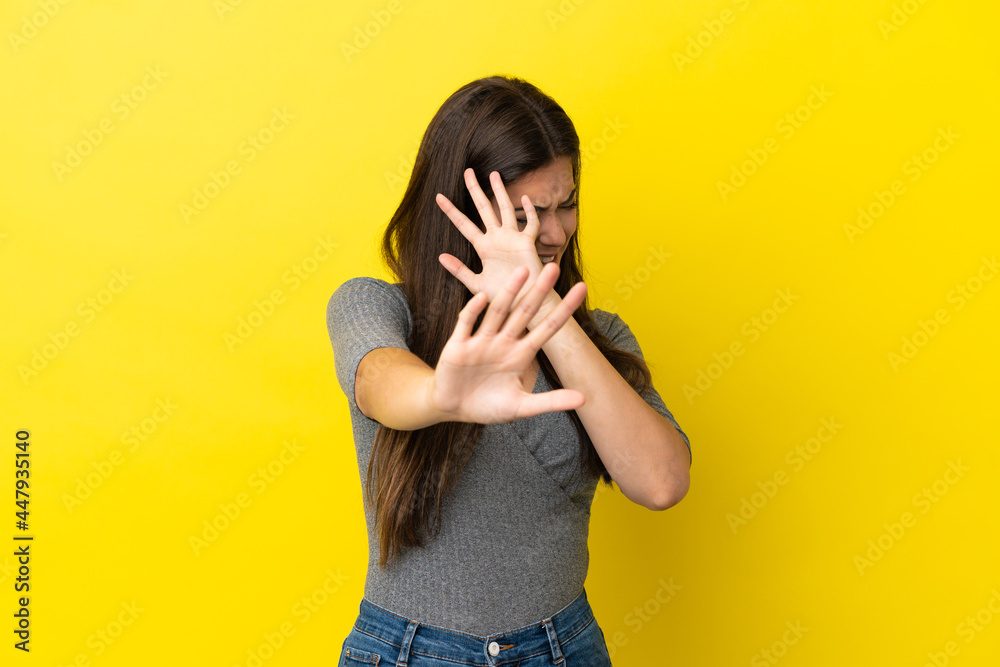 Young Brazilian woman isolated on yellow background nervous stretching hands to the front Young Brazilian woman isolated on yellow background nervous stretching hands to the front