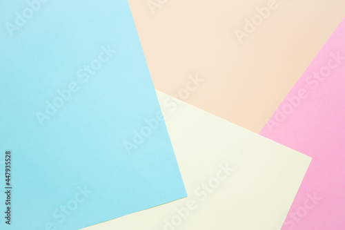 Sheets of colored paper as a background: blue, pink and yellow. Layout, copy space. Geometric print.