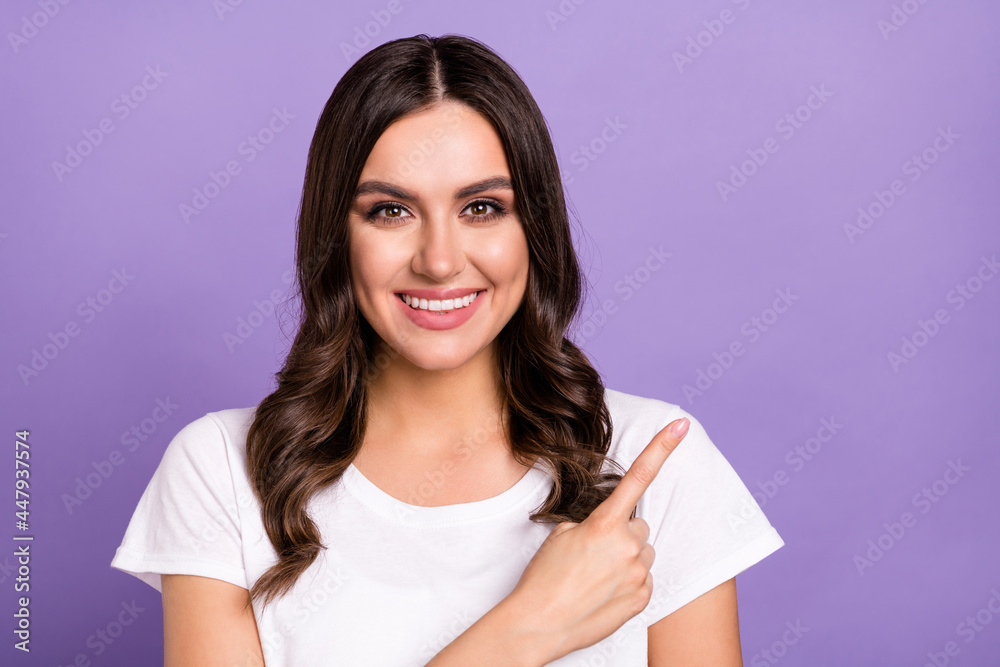Photo of optimistic brunette young lady point empty space wear white t-shirt isolated on violet color background Photo of optimistic brunette young lady point empty space wear white t-shirt isolated on violet color background