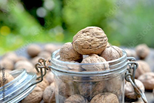 closeup on walnut above others in a glass jar and green background