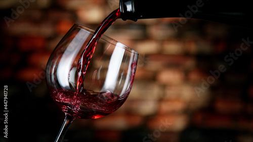 Obraz na plátně Freeze motion of red wine pouring into glass.