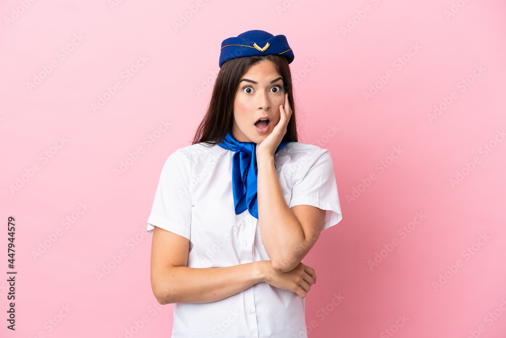 Airplane stewardess Brazilian woman isolated on pink background surprised and shocked while looking right Airplane stewardess Brazilian woman isolated on pink background surprised and shocked while looking right