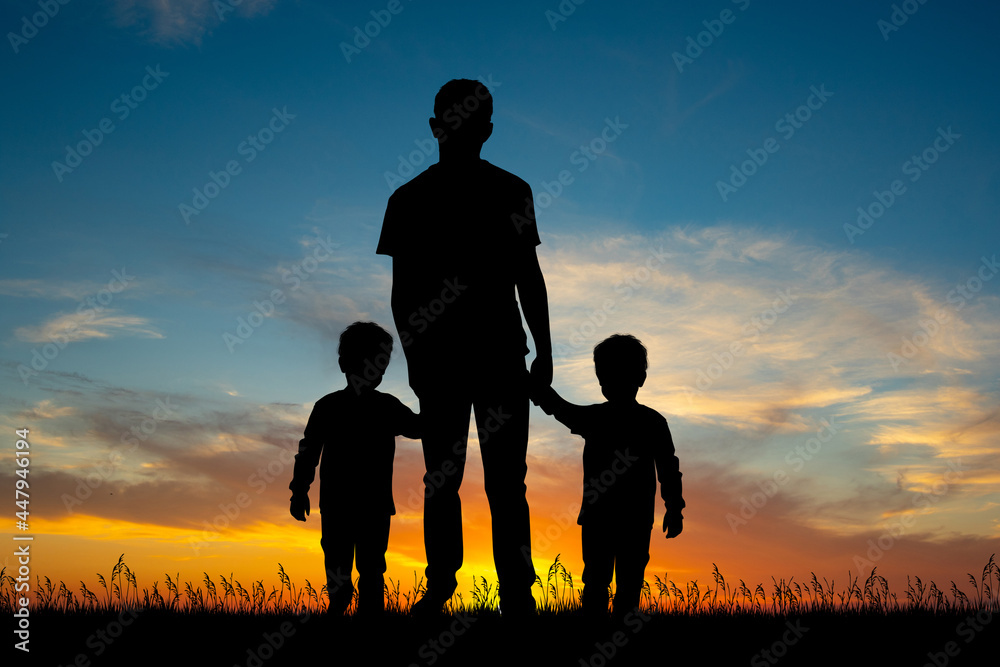 father with twins at sunset