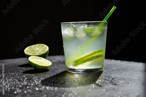 Natural juice with ice and lime on a black background.