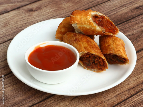 Veg Spring Rolls with sweet chili sauce from a asian cuisine. served over a rustic wooden table. selective focus