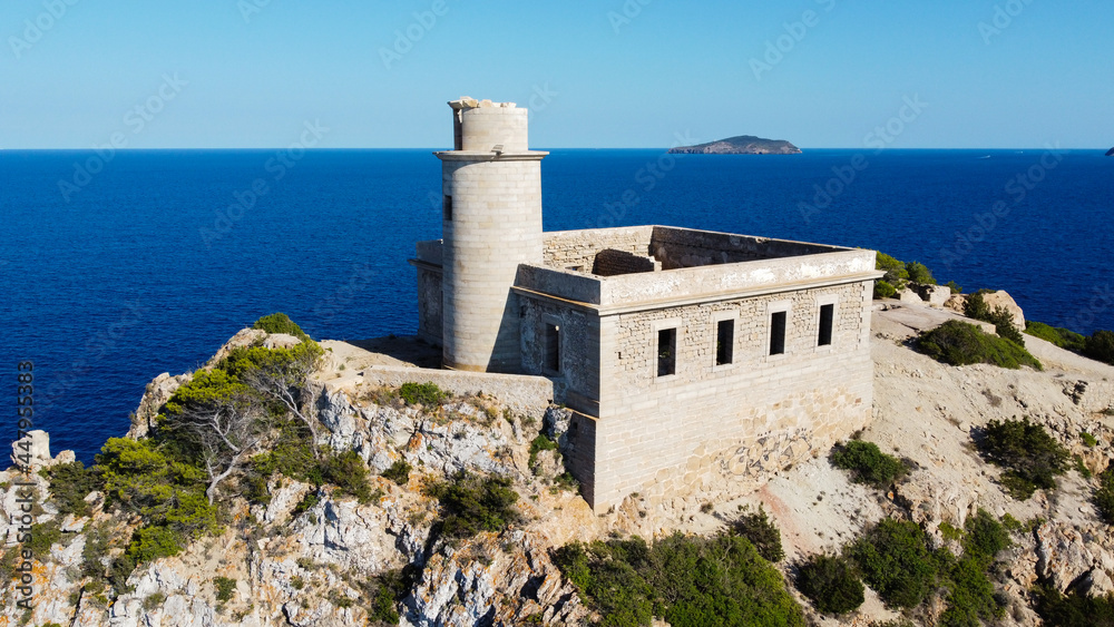 Aerial view of the abandonned lighthouse on the Punta Grossa cape, in the east of Ibiza island in the Balearic Islands, Spain - Ruins of a square based lighthouse with a round tower