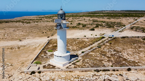 Aerial view of the lighthouse of Cape Barbaria, southwest of Formentera in the Balearic Islands, Spain - Bare landscape of Cabo Berberia with dramatic cliffs diving into the Mediterranean Sea photo