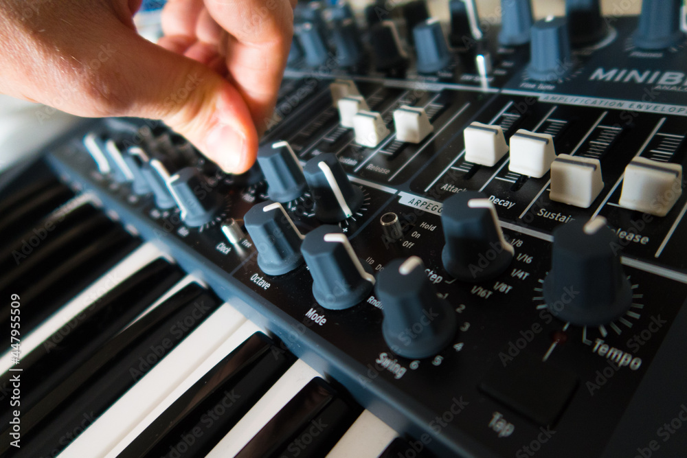 Naklejka premium Synthesiser and hand fingers turning knobs