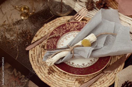 A table  designed for a boho style event with an eucalyptus, vintage plates and other rustic touches. On seaside in the sand dunes