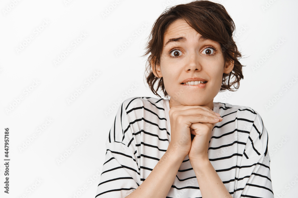 Image of tempted and amazed young woman biting lip and looking with desire, watching something beautiful, standing over white background Image of tempted and amazed young woman biting lip and looking with desire, watching something beautiful, standing over white background