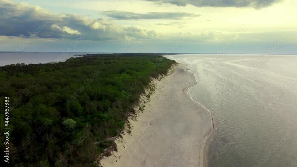 Aerial landscape of a long ridge covered by green plants and bordered by sand shores at cloudy day. Drone footage of the Curonian spit in Kaliningrad. Shoreline of the Baltic sea with grey sky over it Aerial landscape of a long ridge covered by green plants and bordered by sand shores at cloudy day. Drone footage of the Curonian spit in Kaliningrad. Shoreline of the Baltic sea with grey sky over it