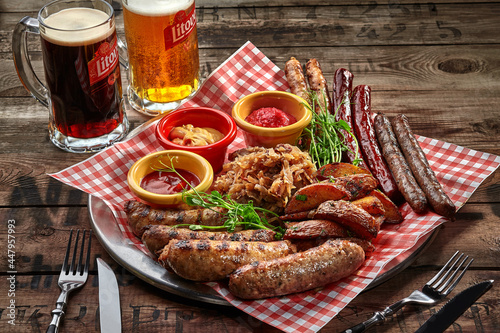Fried sausages, potato wedges, stewed cabbage, sauces as beer snack photo