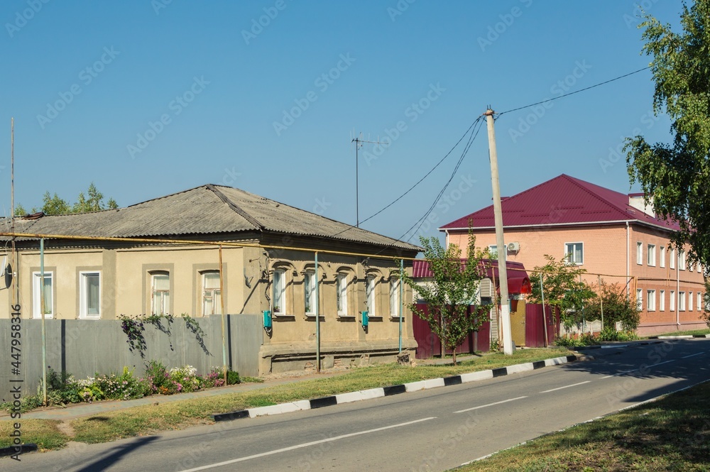 Old street with one and two storey houses on sunny day