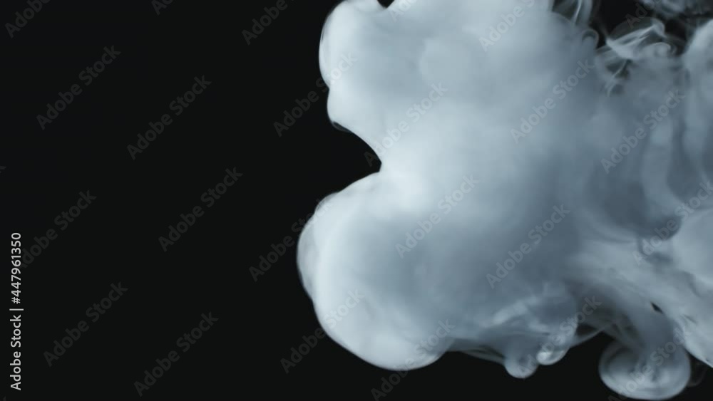 Close up slowmo of clouds of white smoke flowing against black