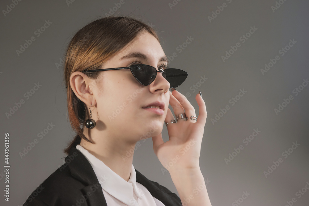 girl in white blouse, black jacket and sunglasses posing girl in white blouse, black jacket and sunglasses posing