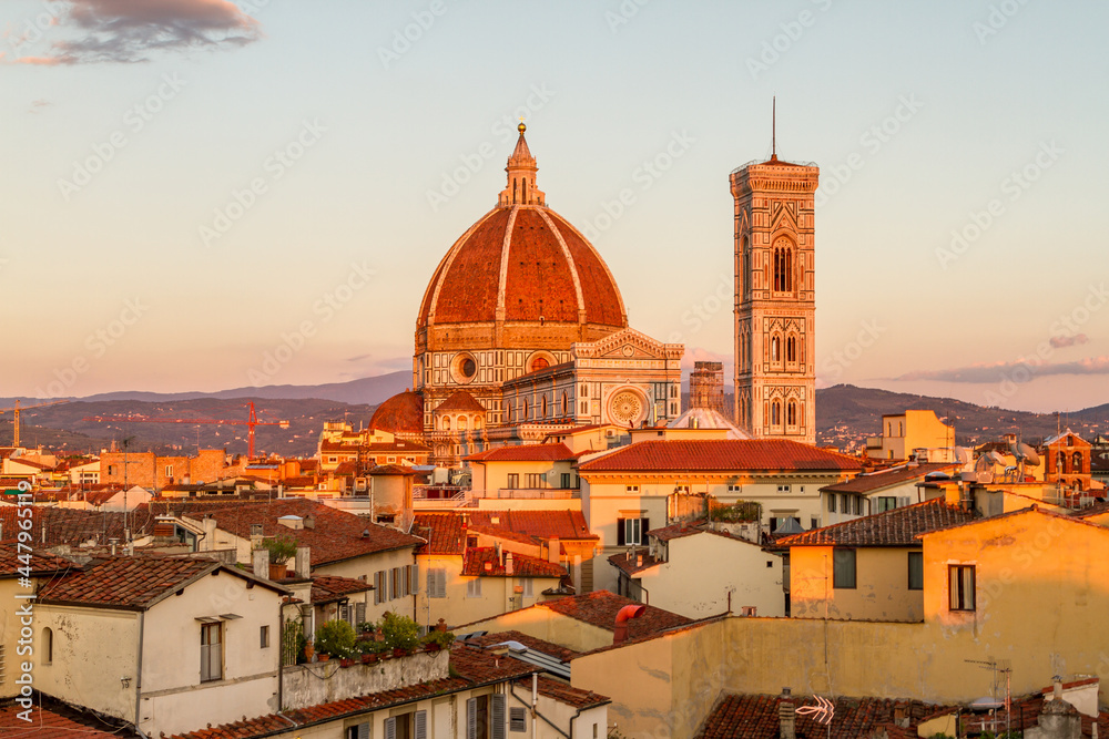 Florence's beautiful Gothic cathedral and bell tower standing out over the surrounding city buildings at sunset