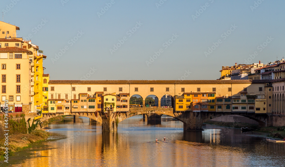 Rowers out on the River Arno during a lovely sunny morning in Florence, Italy, with the historic Ponte Vecchio in the background