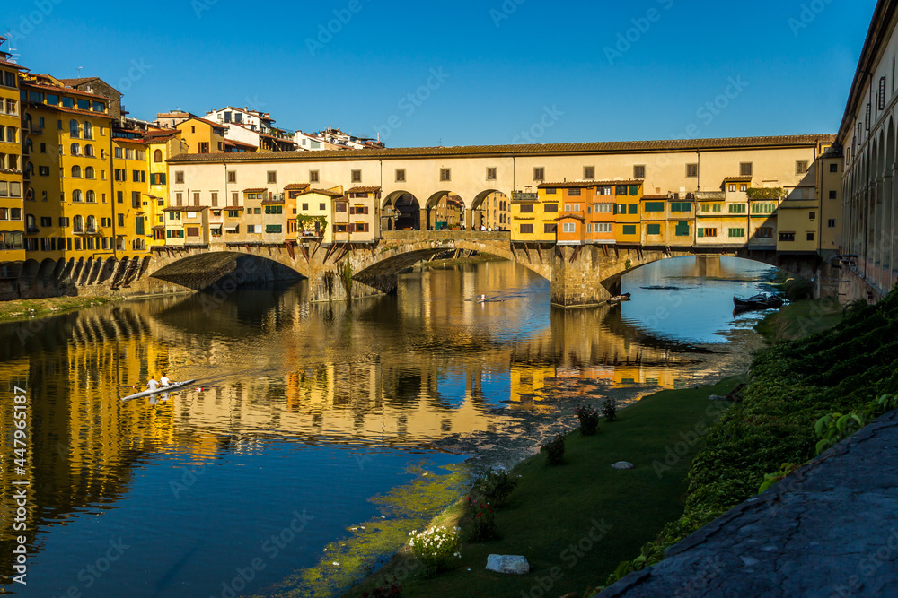 Rowers out on the River Arno during a lovely sunny morning in Florence, Italy, with the historic Ponte Vecchio in the background