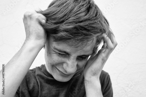 Young man in depression covers his face with his hands