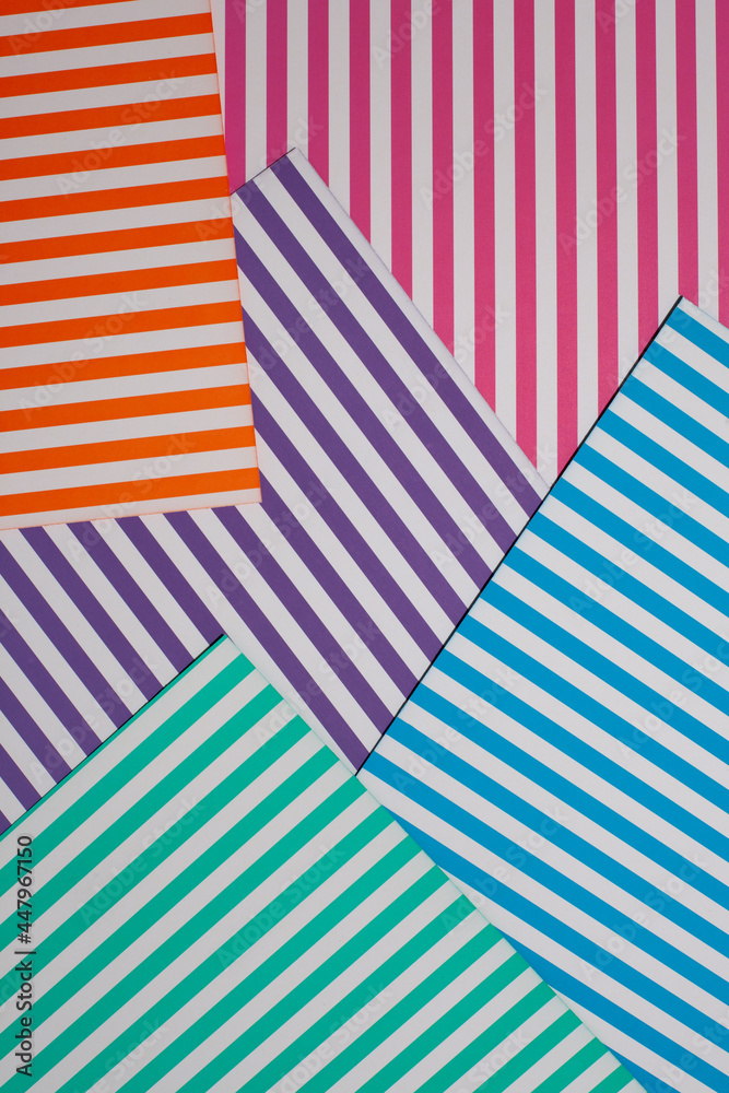 Obraz premium Abstract, geometric background. Top view of a geometric background of striped multicolored paper sheets. 