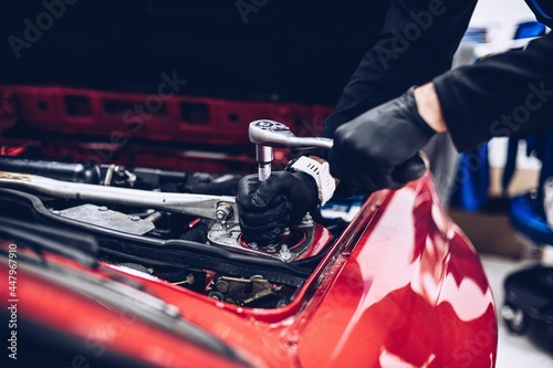 Obraz na płótnie Repairman in car service repairing engine or other car part w salonie