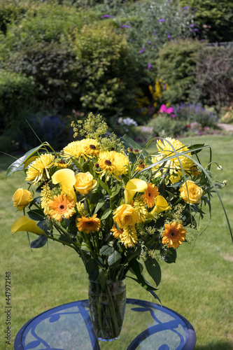 Yellow flowers in a vase on a garden table