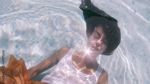 Woman holds her breath underwater in swimming pool