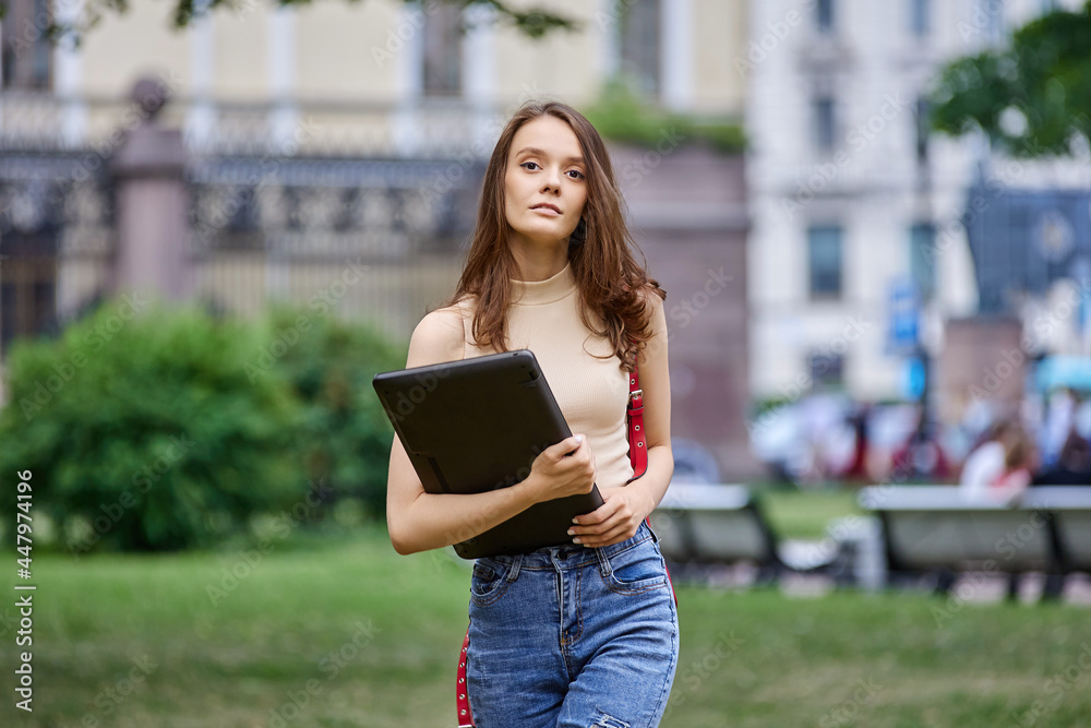 Serious elegant woman with laptop in hands outside. Serious elegant woman with laptop in hands outside.