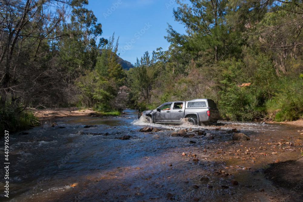 truck 4wd driving through a creek in the bush