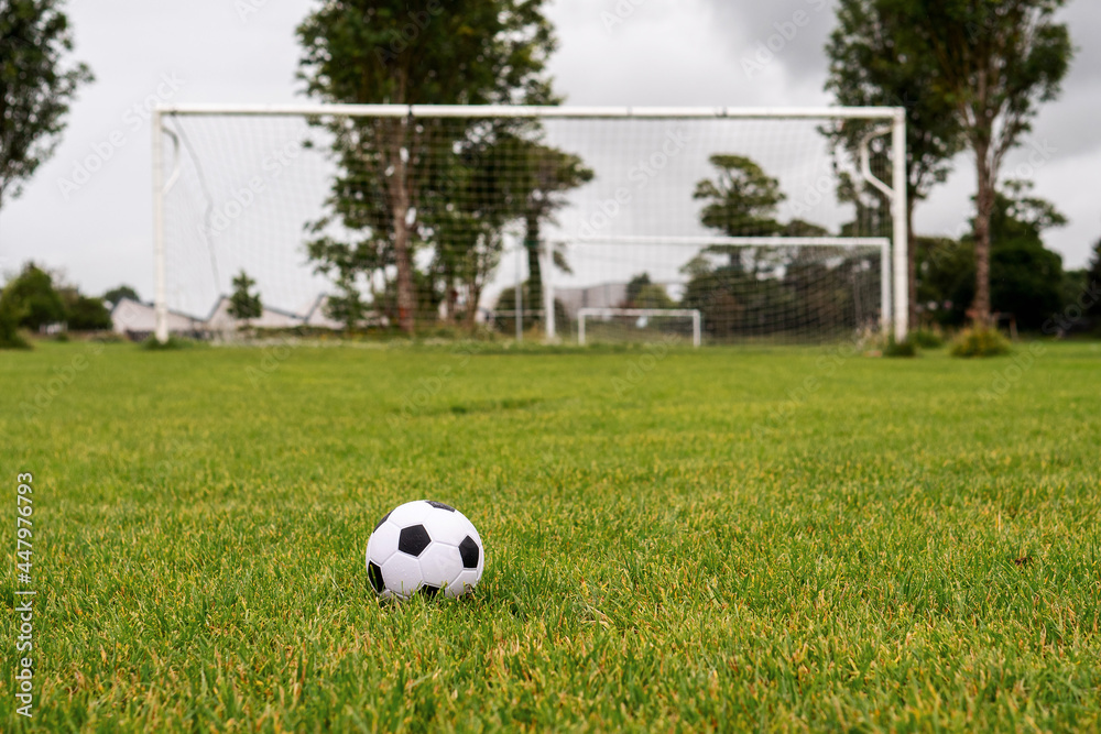 White soccer of football goal post on a grass field of a training ground. White soccer of football goal post on a grass field of a training ground.