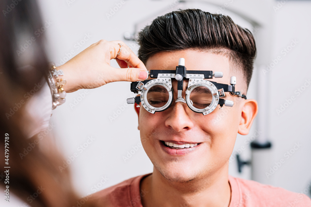 Foto de Primer plano de un Joven hombre con unas gafas de medición para  realizar exámenes de la vista por el oftalmólogo do Stock