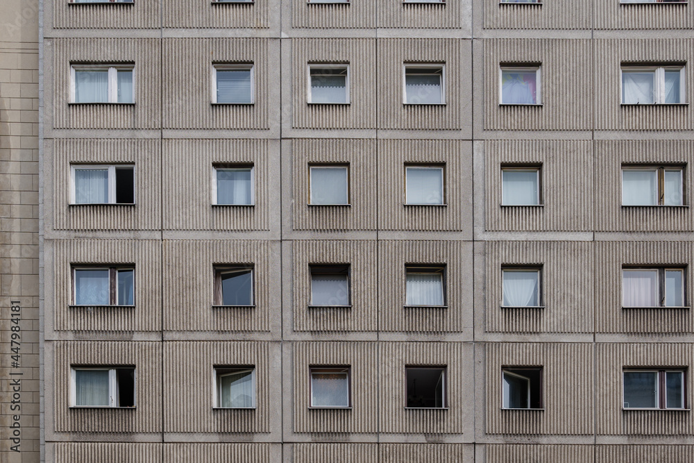 Outdoor sunny street front view of typical modern residence or apartment in city of Europe with rough raw concrete facade, rectangular windows and doors. Outdoor sunny street front view of typical modern residence or apartment in city of Europe with rough raw concrete facade, rectangular windows and doors.