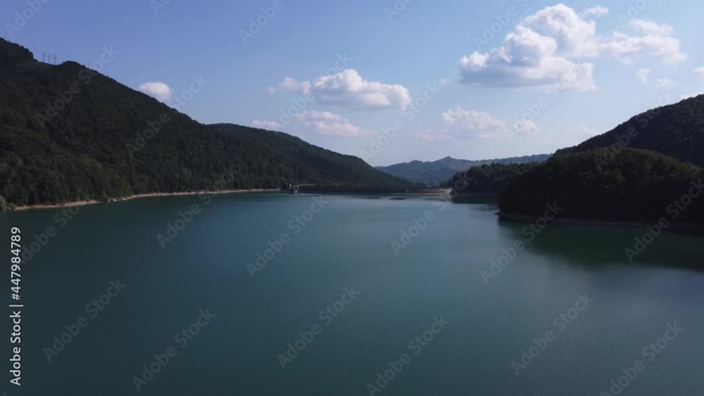 Aerial pull in shot of a modern dam providing green energy for the local villages on Paltinu lake of Doftana Valley in Romania Aerial pull in shot of a modern dam providing green energy for the local villages on Paltinu lake of Doftana Valley in Romania
