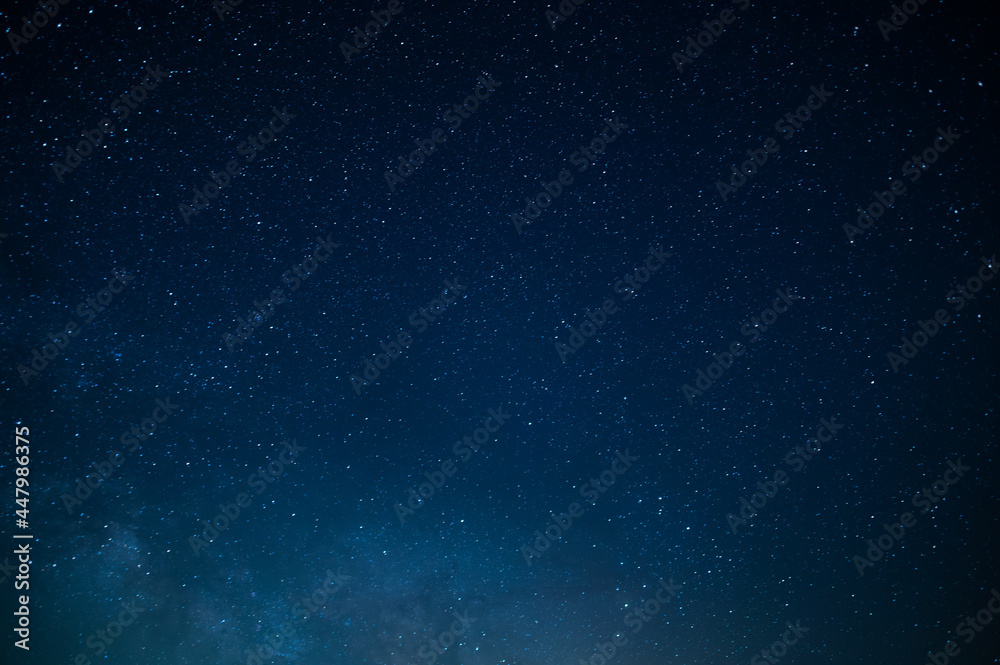 Night starry sky. Many small bright stars twinkle against the deep blue sky. There are no people in the photo. There is a place for your inscription. Background. Texture. Wallpaper.