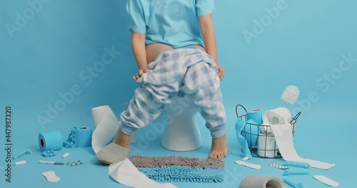 Unknown person runs to toilet very quickly has diarrhea symptoms after eating spoiled food suffers from frequent bowel movements serious disorder poses in lavatory room against blue background