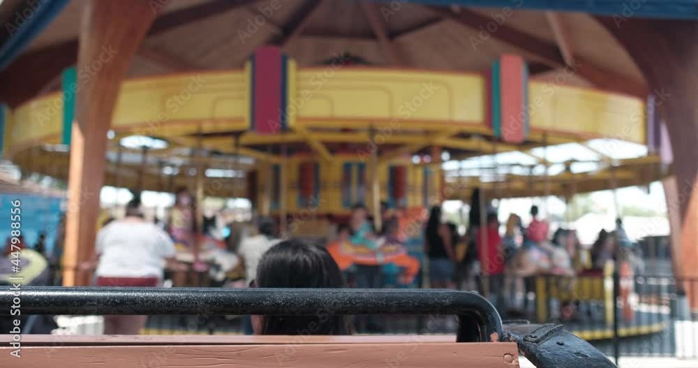 Carosouel spinning with person in foreground Carosouel spinning with person in foreground