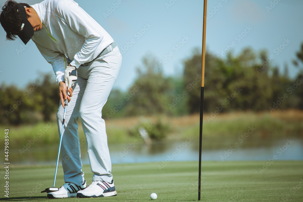 Obraz premium Golfers putting golf balls on the green amid the warm sunshine in the morning. Concept of Outdoor activities and Outdoor sports, Concept of Golfer and Lifestyle.
