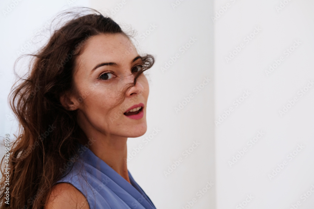 Portrait of pretty brunette wearing stylish blue top. Beautiful caucasian European female